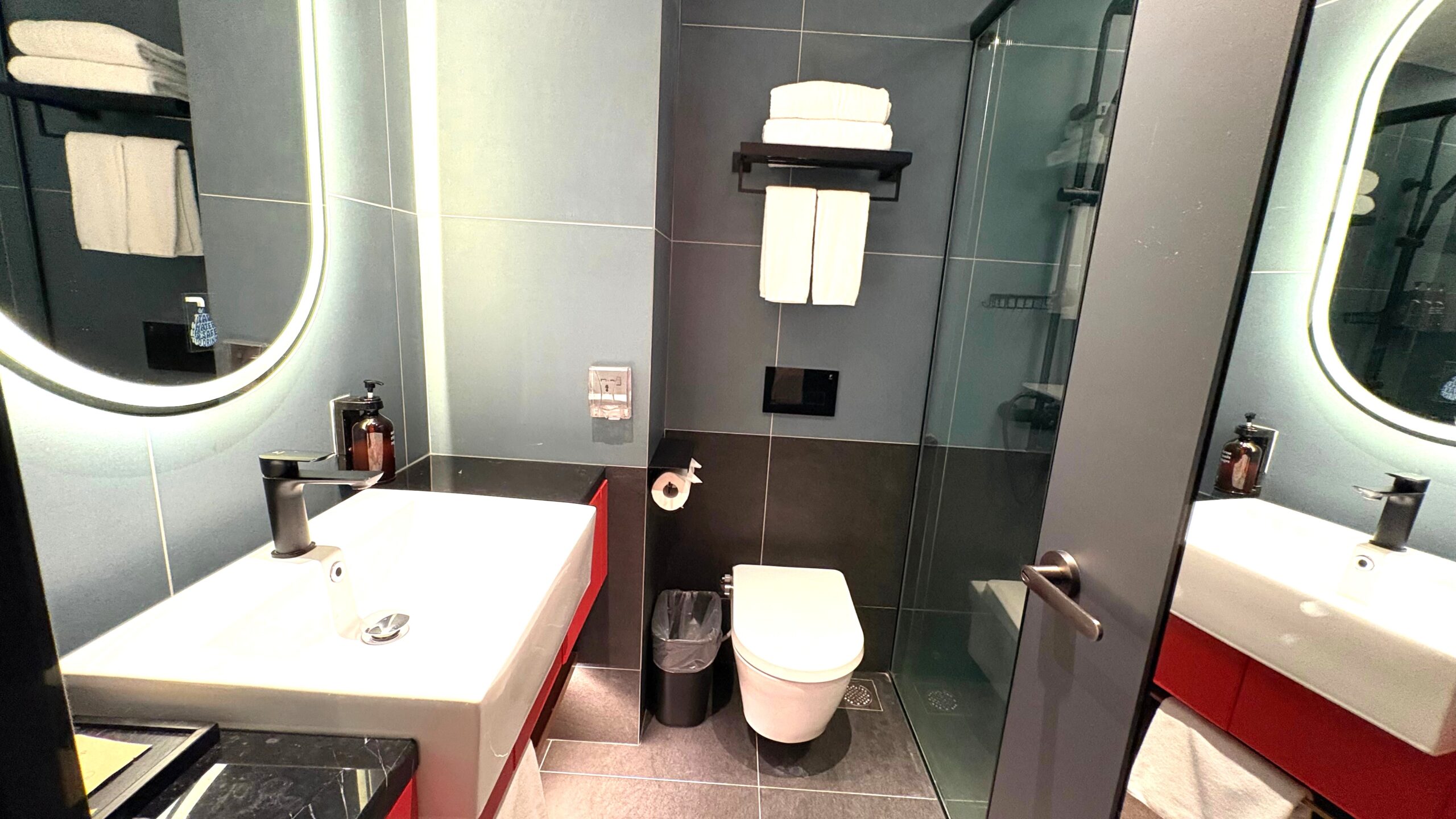 客室の洗面台・トイレとガラスで仕切られたシャワースペース